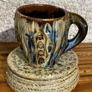 This porcelain coffee cup has local motifs and reliefs that are accented with Japenese clay. The cup is glazed with Huahine glazes found at the bottom of the lagoon.