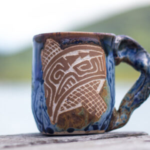 Porcelain coffee mug with stoneware handle and carved tattoo motifs