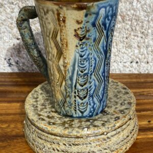 This tall porcelain mug can be used for hot or cold beverages. It is decorated with local motifs and Japanese clay to give an extra relief; and it is glazed with our famous Huahine glaze found at the bottom of the lagoon while pearlfarming.