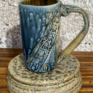 Tall porcelain mug with a sculpted stoneware handle